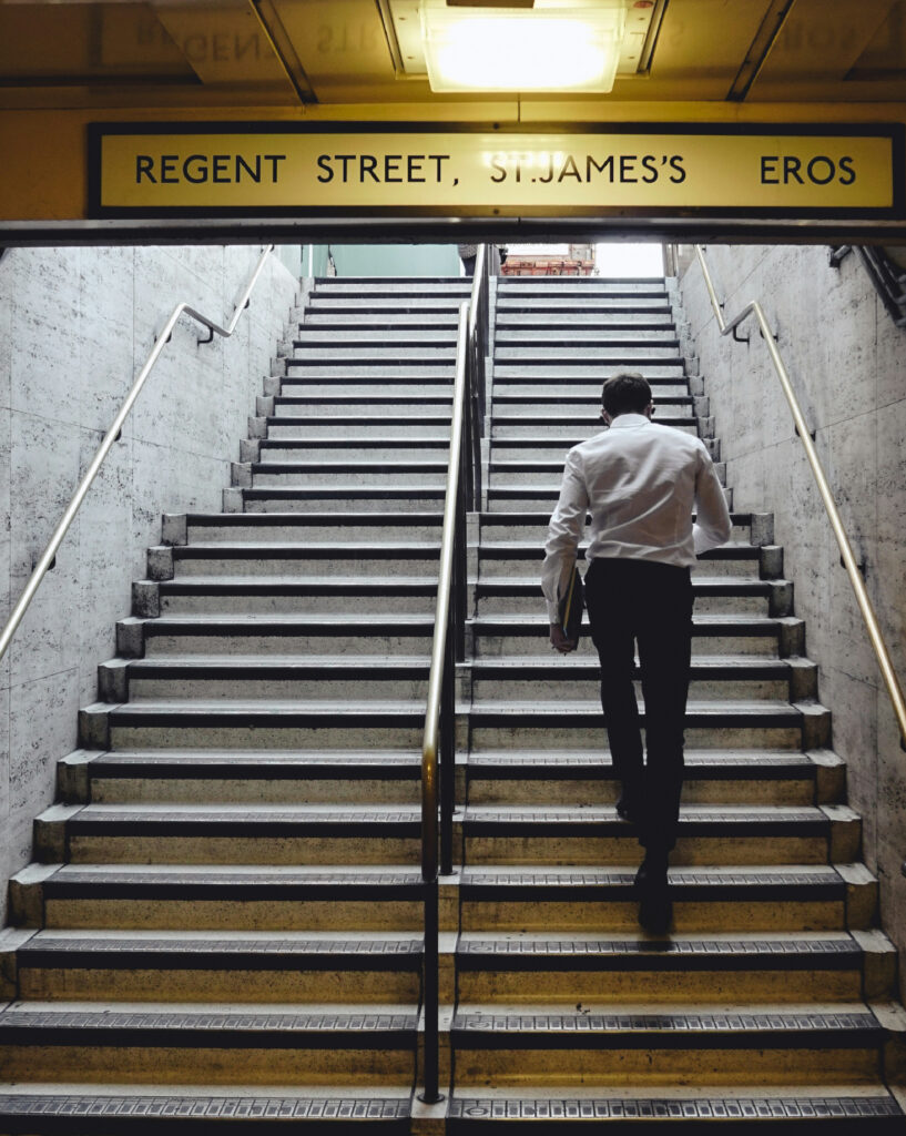 hombre de negocios subiendo las escaleras de una estación de metro