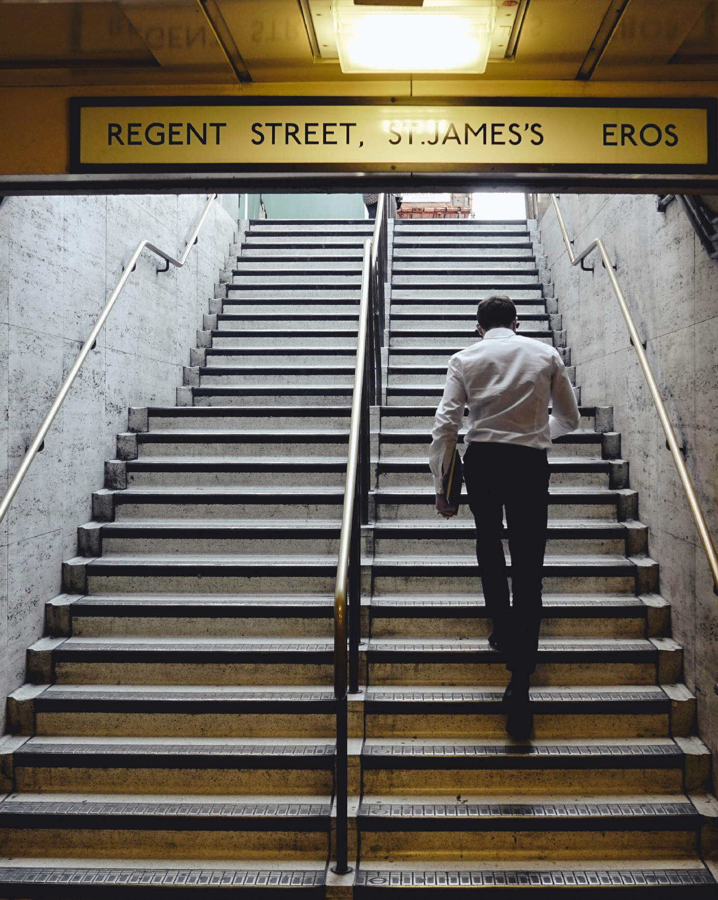 hombre de negocios subiendo las escaleras de una estación de metro